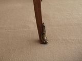 a chair that has a wooden seat and legs on it