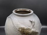 un vase blanc orné d'un oiseau, posé sur une table