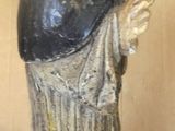 a statue of a woman holding a cup on a bed