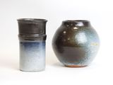 two vases sitting next to each other on a white surface