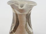 a white and brown vase sitting on a white surface