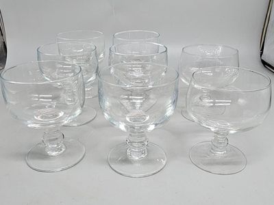 six wine glasses sitting on a white table