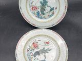 deux assiettes ornées d'oiseaux et de fleurs, posées sur une table