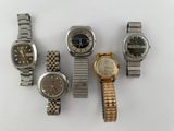 several different watches are arranged in a row on a white surface