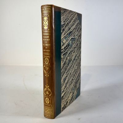 an old book sitting on top of a white table next to a white wall