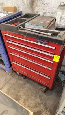 une armoire à outils rouge sur laquelle sont posés de nombreux outils