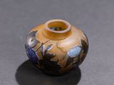 a yellow vase with blue flowers on it sitting on a table