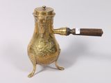 an antique brass teapot with a wooden handle on a white background