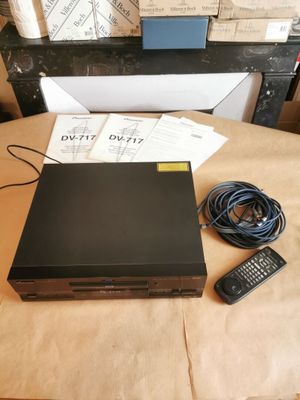 un lecteur DVD posé sur une table, à côté d'une télécommande