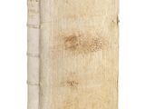 an old book sitting on top of a white table next to a white wall