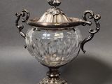 an antique silver plated sugar dish with a glass lid