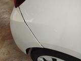 a white car with a black rim parked in a garage