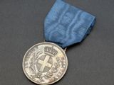 un gros plan d'une médaille ornée d'un ruban bleu sur un fond noir