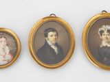 trois portraits miniatures représentant un homme et une femme sont exposés dans un cadre doré