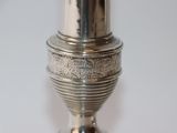 a silver vase on a table with a white background