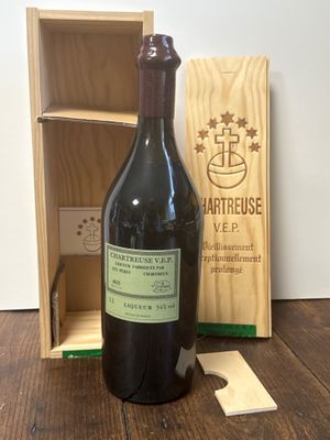 une bouteille de vin posée sur une table à côté d'une caisse en bois