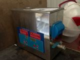 a machine that is sitting on the floor next to a bucket