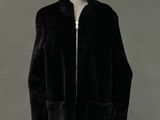 an image of a mannequin wearing a black coat with a hood