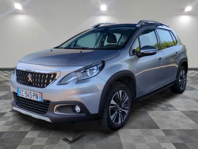 une voiture argentée garée dans un garage au sol en damier