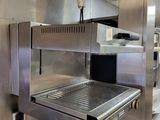 a large stainless steel oven in a commercial kitchen