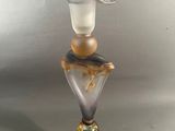 un vase en verre surmonté d'un oiseau