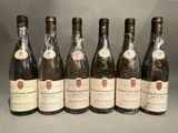 six bouteilles de vin sont alignées sur une table
