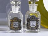 three bottles of perfume sitting on a counter next to a clock