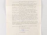 an old document with a handwritten letter on it sitting on a table
