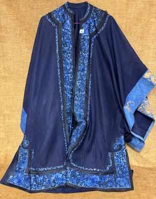 une veste bleue et noire avec des bordures bleues sur fond beige clair