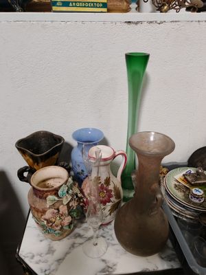 il y a de nombreux vases et plats sur le comptoir dans cette pièce