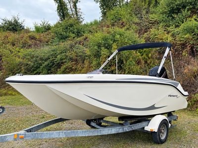a boat that is parked on a trailer in the grass