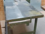 une table sur laquelle est posée une scie, au milieu d'une pièce