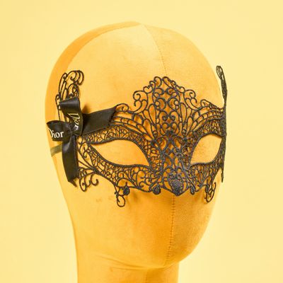 un masque en dentelle noire sur une tête de mannequin