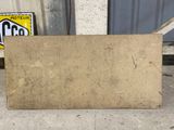 a large piece of cardboard on the ground next to a gas station sign