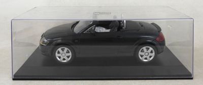 une petite voiture noire dans une vitrine transparente