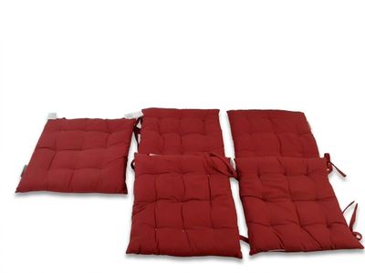 trois coussins rouges munis de liens, sur fond blanc