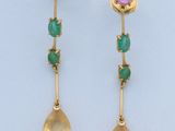 une photo d'une paire de boucles d'oreilles en or ornées de pierres vertes et violettes