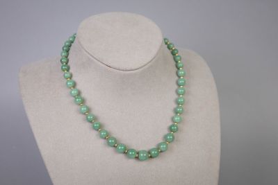 un collier de perles vertes sur un mannequin d'exposition
