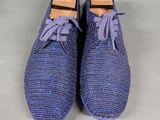 men ' s blue shoes with purple laces on them on a gray surface