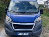 the blue van is parked on the side of a dirt road