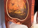 a wooden clock with a painting on the front of it