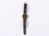 a close up of a watch on a white surface with a white background