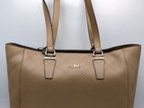 a close up of a tan handbag on a white background