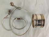 a silver object on a white cloth with a pair of ear buds