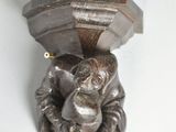 statue of a monkey holding a hammer on a white surface