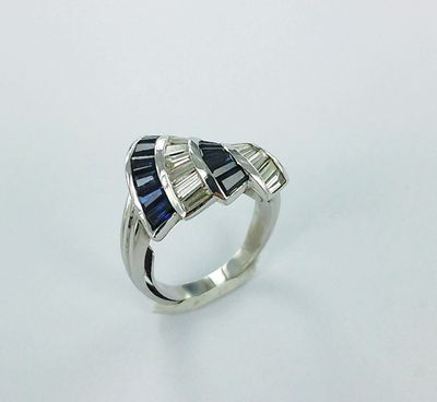 un gros plan d'une bague ornée de pierres bleues et blanches
