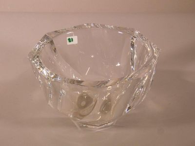 un saladier en verre transparent posé sur une surface blanche