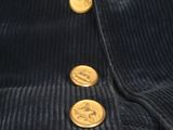 a close up of a black cordurope jacket with gold buttons