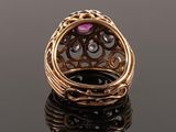 a close up of a gold ring with a pink stone