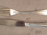 two forks and a knife sitting on a table